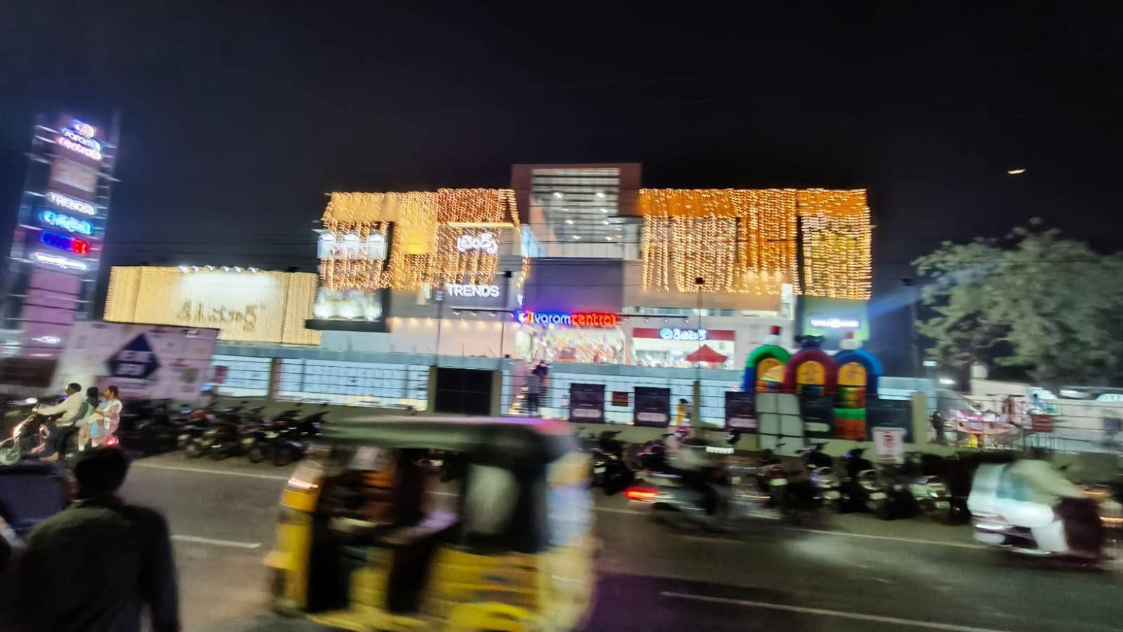 Varam Central lit up at night with festive lighting across the facade and PVR signage tower